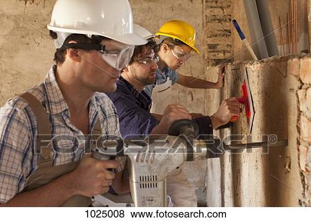 Manual workers working at a building site View Large Photo Image Stock Photo - Manual workers working at a building site. Fotosearch