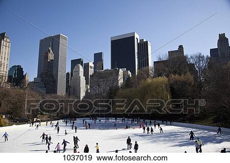 Many people ice skating with tall New York buildings in the background View Large Photo Image Stock Photo - Many people ice skating with tall New York buildings in the background. Fotosearch
