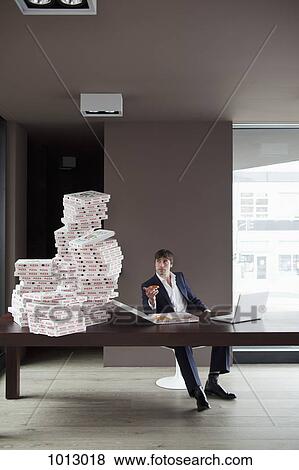 Stock Photo - Many pizzas on table for businessman working at home. . Fotosearch