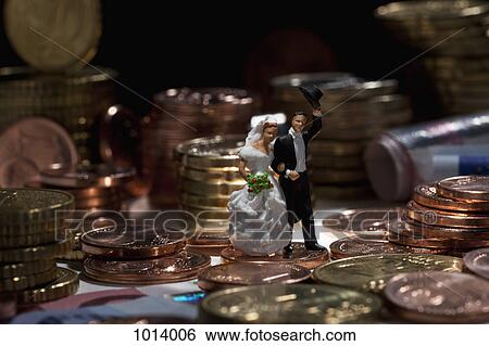 Miniature wedding couple figurines amidst stacks of European Union coins View Large Photo Image Stock Photograph - Miniature wedding couple figurines amidst stacks of European Union coins. Fotosearch