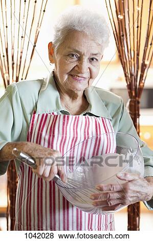 Portrait of a senior woman mixing ingredients in a bowl View Large Photo Image Stock Photo - Portrait of a senior woman mixing ingredients in a bowl. Fotosearch