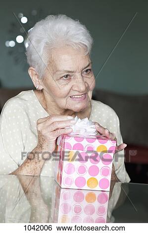 Portrait of a senior woman with a present View Large Photo Image Stock Photograph - Portrait of a senior woman with a present. Fotosearch