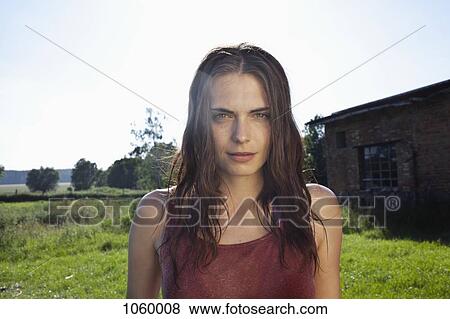 Stock Photo - Profile of girl in field with barn in background. Fotosearch