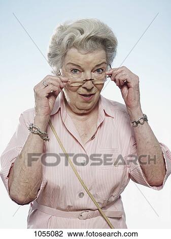 Profile of senior woman peering over her glasses View Large Photo Image Stock Image - Profile of senior woman peering over her glasses . Fotosearch