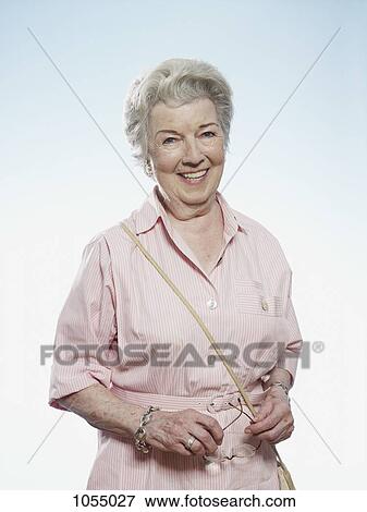 Profile of smiling senior woman holding her glasses View Large Photo Image Stock Photo - Profile of smiling senior woman holding her glasses. Fotosearch
