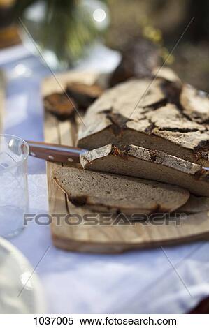Rye bread partly sliced on a bread board outside View Large Photo Image Stock Photography - Rye bread partly sliced on a bread board outside. Fotosearch