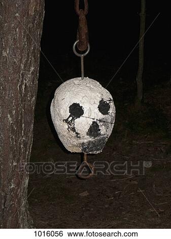 Stock Photograph - Scary mask hanging from tree.. Fotosearch