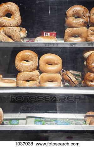 Selection of bagels on shelves behind a shop window View Large Photo Image Stock Photo - Selection of bagels on shelves behind a shop window. Fotosearch