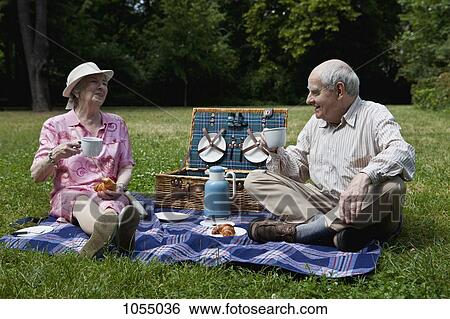 Senior couple enjoying picnic in the park View Large Photo Image Stock Photograph - Senior couple enjoying picnic in the park. Fotosearch