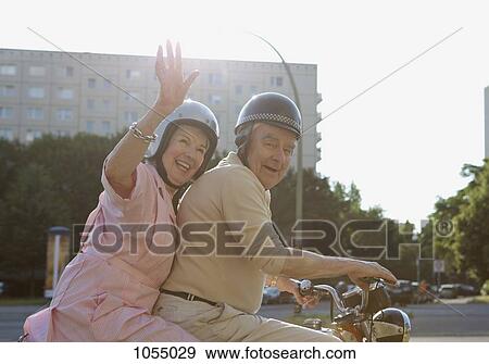 Senior couple happy on motorbike as woman waves View Large Photo Image Stock Photo - Senior couple happy on motorbike as woman waves. Fotosearch