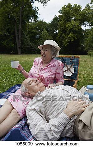 Senior couple have relaxing picnic in the park View Large Photo Image Stock Photo - Senior couple have relaxing picnic in the park. Fotosearch