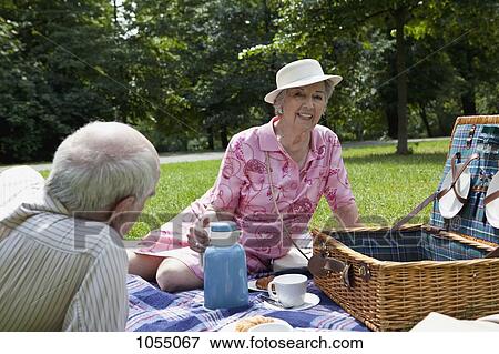 Senior couple having relaxing picnic in park View Large Photo Image Stock Photo - Senior couple having relaxing picnic in park. Fotosearch