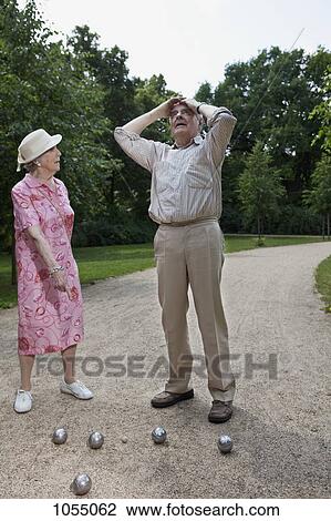 Senior couple having sports dispute as they play Boules in the park View Large Photo Image Stock Image - Senior couple having sports dispute as they play Boules in the park. Fotosearch