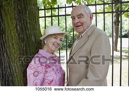 Senior couple in park smile at camera View Large Photo Image Stock Photograph - Senior couple in park smile at camera. Fotosearch