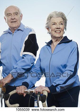Senior man and woman in sportswear holding bicycles View Large Photo Image Stock Photo - Senior man and woman in sportswear holding bicycles. Fotosearch