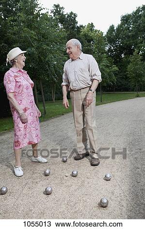 Senior man and woman play Boules in the park View Large Photo Image Stock Image - Senior man and woman play Boules in the park. Fotosearch