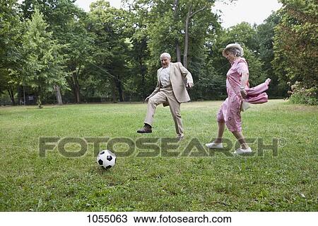 Senior man and woman play football in the park View Large Photo Image Stock Image - Senior man and woman play football in the park. Fotosearch