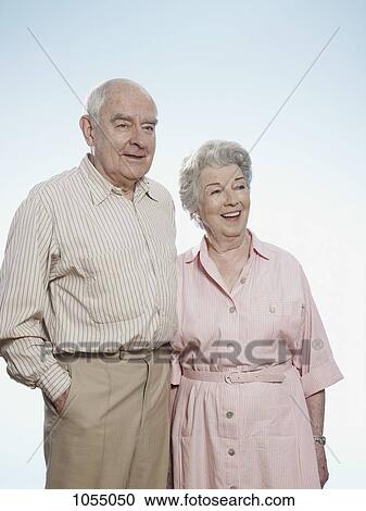 Stock Image - Senior man and woman side by side looking amused. Fotosearch