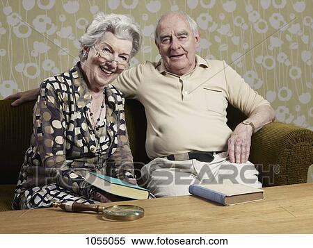 Senior man and woman with books on the couch View Large Photo Image Stock Photography - Senior man and woman with books on the couch. Fotosearch