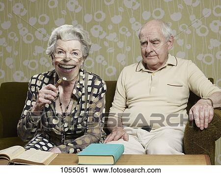 Senior man frowns as senior woman magnifies appearance of her mouth with magnifying glass View Large Photo Image Stock Image - Senior man frowns as senior woman magnifies appearance of her mouth with magnifying glass. Fotosearch