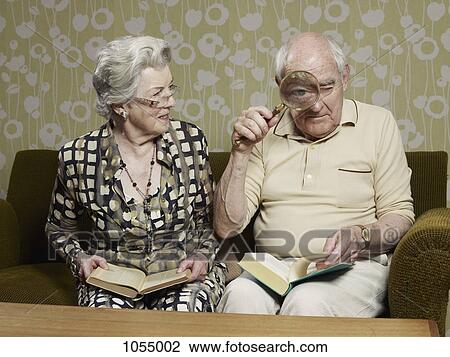Senior man looking through magnifying glass making his eye appear bigger View Large Photo Image Stock Image - Senior man looking through magnifying glass making his eye appear bigger. Fotosearch
