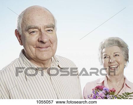 Senior man looks pleased that she likes the flowers View Large Photo Image Stock Photo - Senior man looks pleased that she likes the flowers. Fotosearch