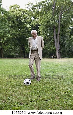 Senior man relaxed and playing football in park View Large Photo Image Stock Image - Senior man relaxed and playing football in park. Fotosearch
