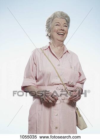Senior woman laughing as she holds her glasses View Large Photo Image Stock Photography - Senior woman laughing as she holds her glasses. Fotosearch