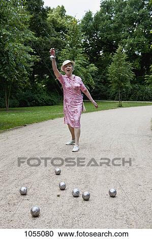 Senior woman plays Boules in the park View Large Photo Image Stock Image - Senior woman plays Boules in the park. Fotosearch