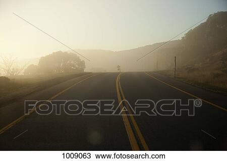 Sunlight and mist over a highway road View Large Photo Image Stock Image - Sunlight and mist over a highway road. Fotosearch