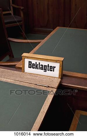 The German word, Beklagter, for defendant on a sign, among some tables and chairs. View Large Photo Image Picture - The German word, Beklagter, for defendant on a sign, among some tables and chairs.. Fotosearch