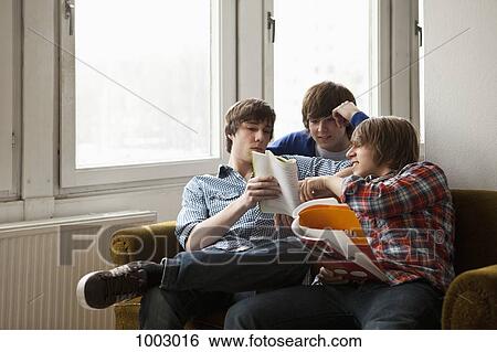 Three friends studying together in a living room View Large Photo Image Stock Photograph - Three friends studying together in a living room. Fotosearch