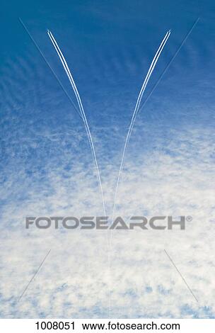 Stock Image - Two airplanes and vapor trails in the sky. Fotosearch