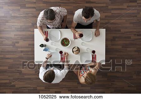 Two friends raising their glasses in a toast at a dinner party, overhead view View Large Photo Image Stock Photography - Two friends raising their glasses in a toast at a dinner party, overhead view. Fotosearch
