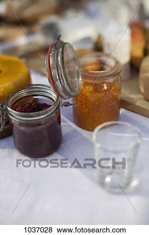 Two jars of preserves on a dining table View Large Photo Image Stock Photo - Two jars of preserves on a dining table. Fotosearch
