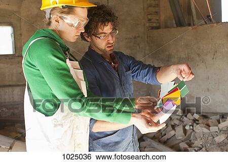 Two manual workers reviewing color samples on a building site View Large Photo Image Stock Photograph - Two manual workers reviewing color samples on a building site. Fotosearch