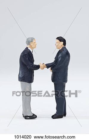 Two miniature businessmen figurines shaking hands View Large Photo Image Stock Image - Two miniature businessmen figurines shaking hands. Fotosearch