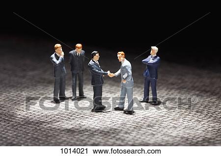 Two miniature businessmen figurines shaking hands amongst other businessmen figurines View Large Photo Image Stock Image - Two miniature businessmen figurines shaking hands amongst other businessmen figurines. Fotosearch
