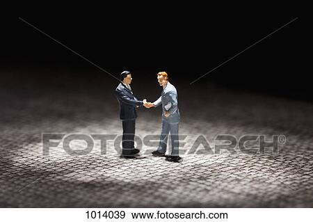 Two miniature businessmen figurines shaking hands View Large Photo Image Stock Photo - Two miniature businessmen figurines shaking hands. Fotosearch