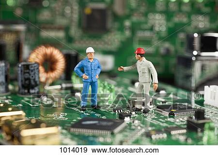 Two miniature figurine men working on a computer mother board View Large Photo Image Stock Photo - Two miniature figurine men working on a computer mother board. Fotosearch