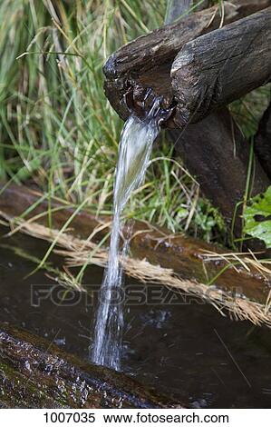 Water running from a wooden drain View Large Photo Image Stock Photography - Water running from a wooden drain. Fotosearch