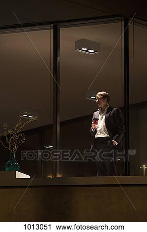 Well dressed man with wine glass looking out of apartment window. View Large Photo Image Stock Image - Well dressed man with wine glass looking out of apartment window.. Fotosearch