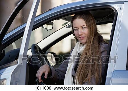 Woman exits car View Large Photo Image Stock Photo - Woman exits car. Fotosearch