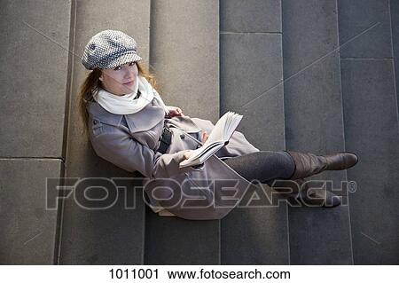 Woman outside on steps with book View Large Photo Image Stock Image - Woman outside on steps with book. Fotosearch