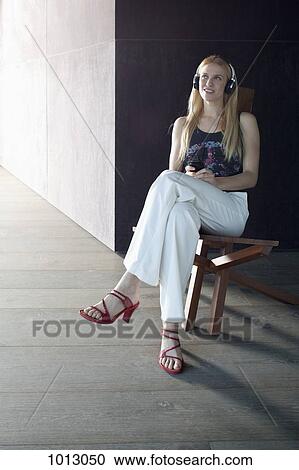 Woman sitting content listening to her headphones. View Large Photo Image Stock Image - Woman sitting content listening to her headphones.. Fotosearch