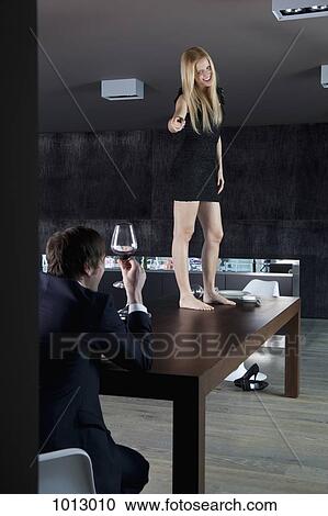 Woman stands on table smiling and pointing at boyfriend. View Large Photo Image Stock Image - Woman stands on table smiling and pointing at boyfriend.. Fotosearch