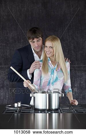 Woman stirring saucepan while boyfriend has hands on her shoulders and is looking at the food. View Large Photo Image Stock Photo - Woman stirring saucepan while boyfriend has hands on her shoulders and is looking at the food.. Fotosearch