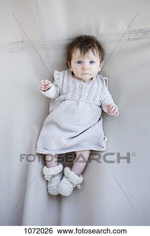 Stock Photograph - A baby lying on a blanket, looking up. Fotosearch