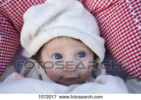 Stock Photo - A baby wearing a hooded shirt, looking up. Fotosearch