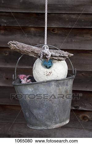 A bucket hanging from a rope tied to a buoy and piece of driftwood View Large Photo Image Stock Image - A bucket hanging from a rope tied to a buoy and piece of driftwood. Fotosearch